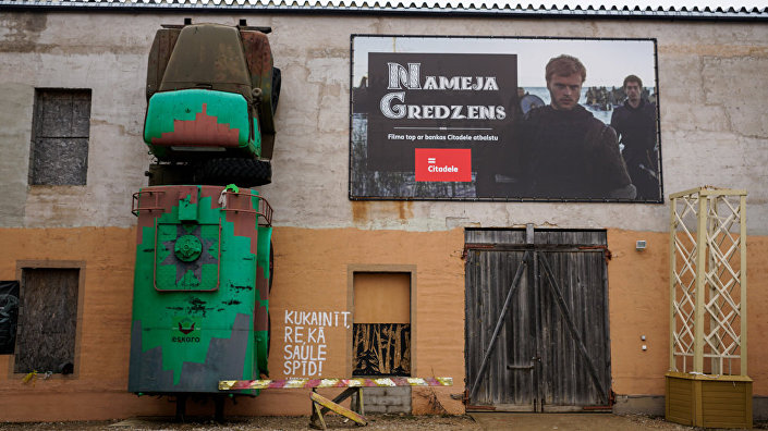 Реклама нового фильма Кольцо Намейса соседствует рядом с взбирающимся на стену Уралом